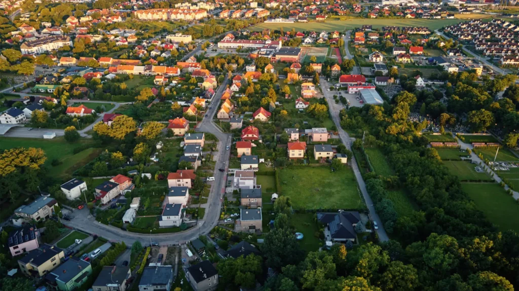Aerial sunset view of serene Perth suburb with red-roofed homes and green streets. Perfect Perth real estate by trusted real estate agents.